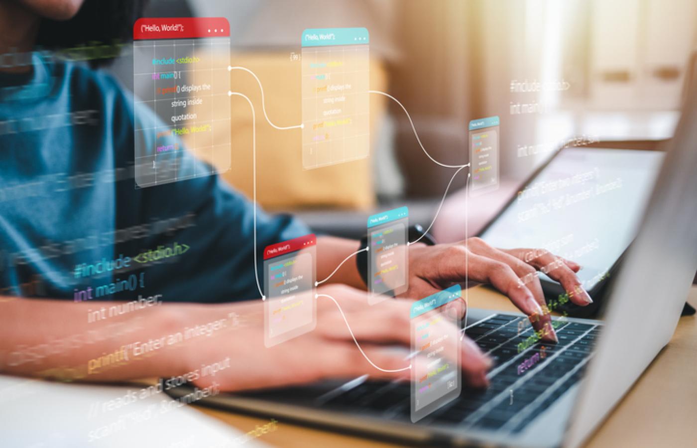 Close up image of hands typing on a laptop keyboard.