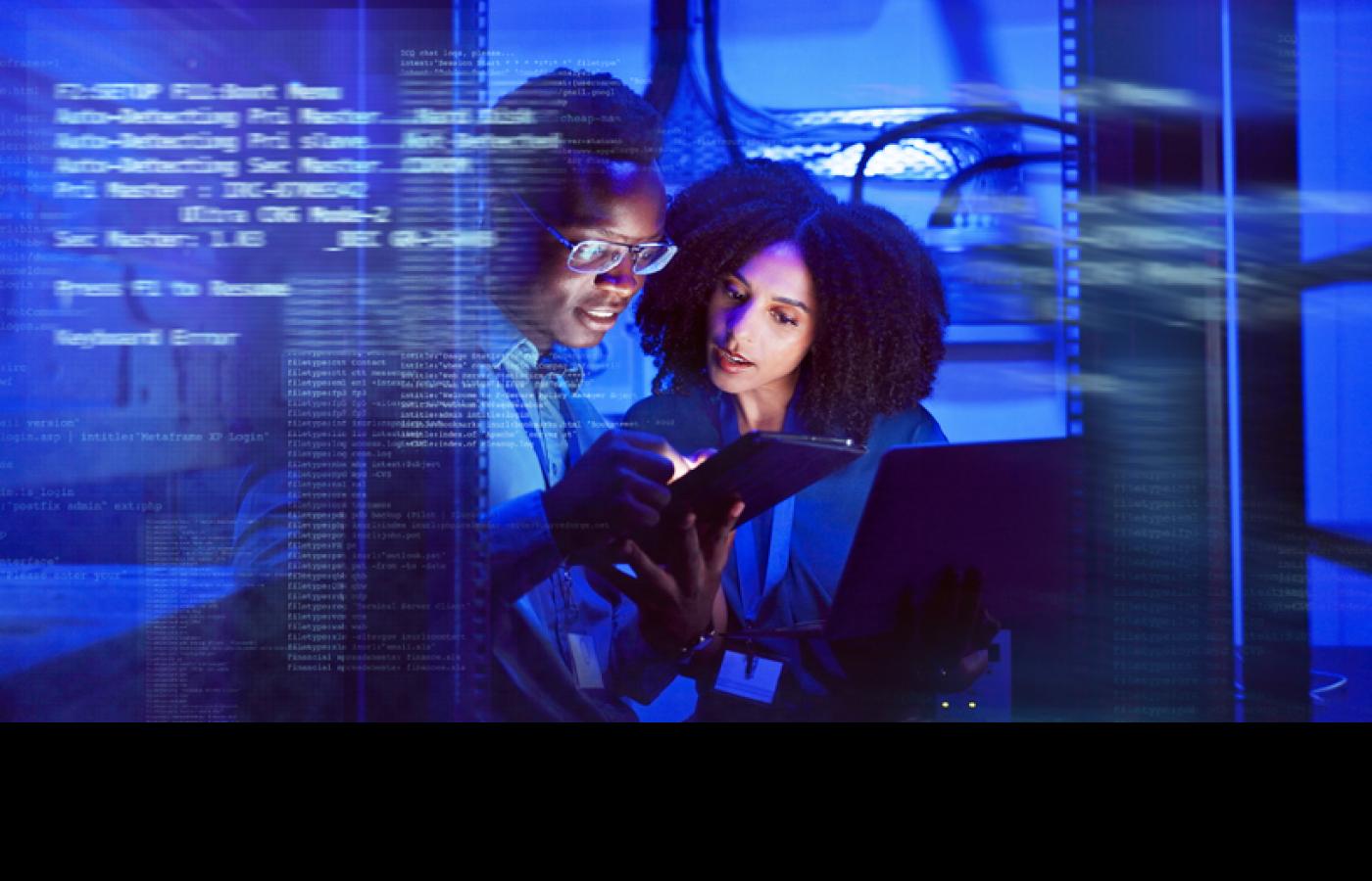 Two professionals look at a tablet together with code overlaying the image.