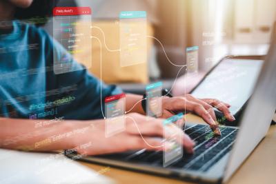 Close up image of hands typing on a laptop keyboard.
